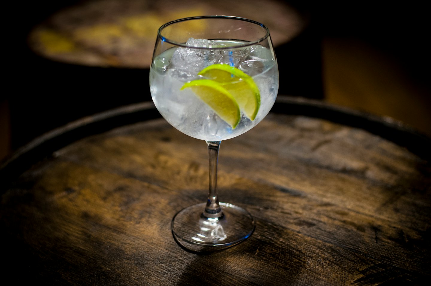 Cocktail gin tonic con lime su un barile di legno.
